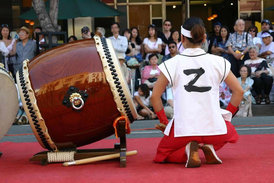 Taiko drummer kneels next to drum in Los Angeles, 2004